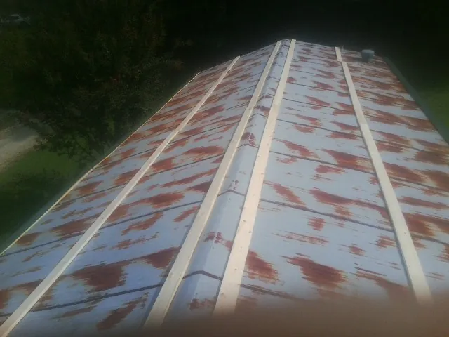 Rusted metal roof panels with new wood purlins before replacement — Storm Damage Roof Repair in Whitakers by Roofing Brothers