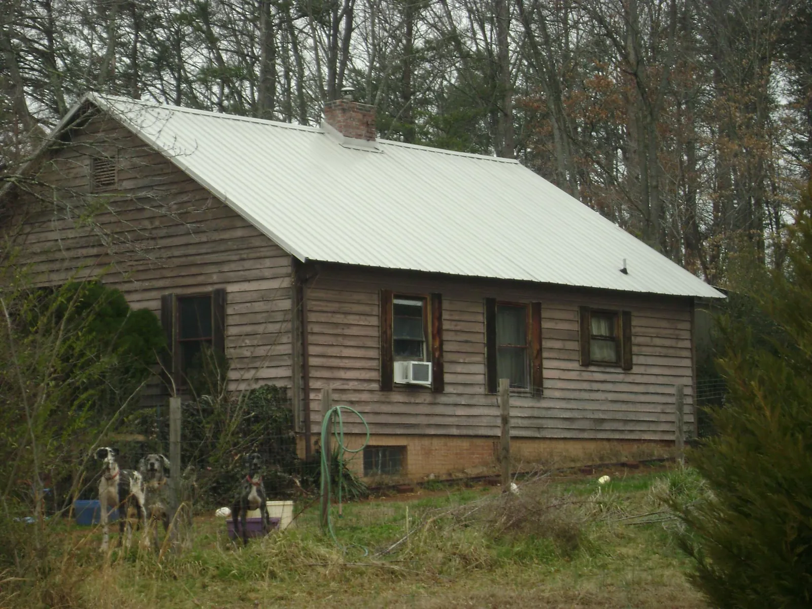 White metal roof on an old wood sided farmhouse, from a Metal Roof Installation job in Whitakers